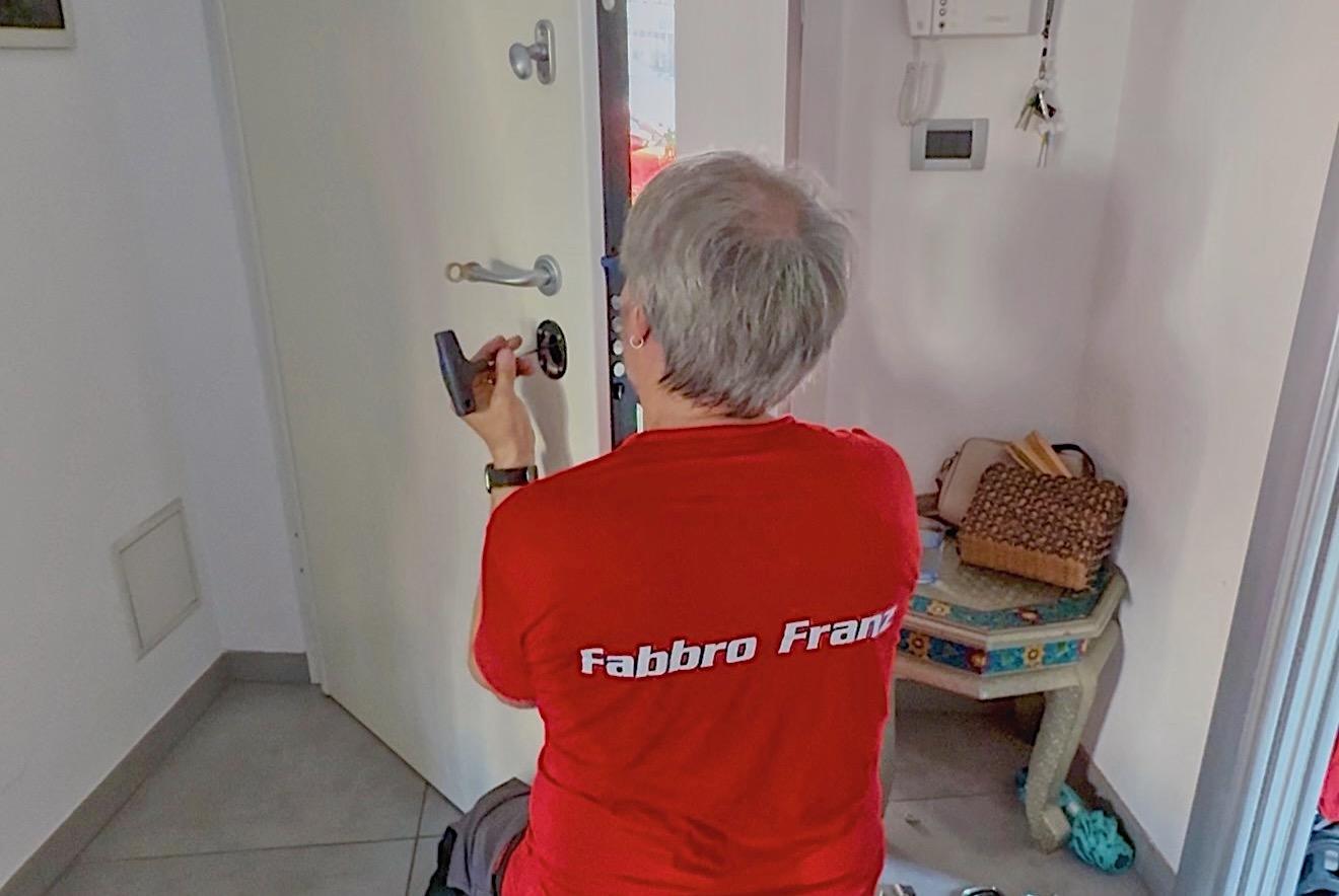 Franz mentre installa un defender magnetico su una porta a Trieste