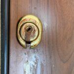 Serratura di una porta danneggiata da sostanza corrosiva dopo un tentativo di effrazione a Trieste