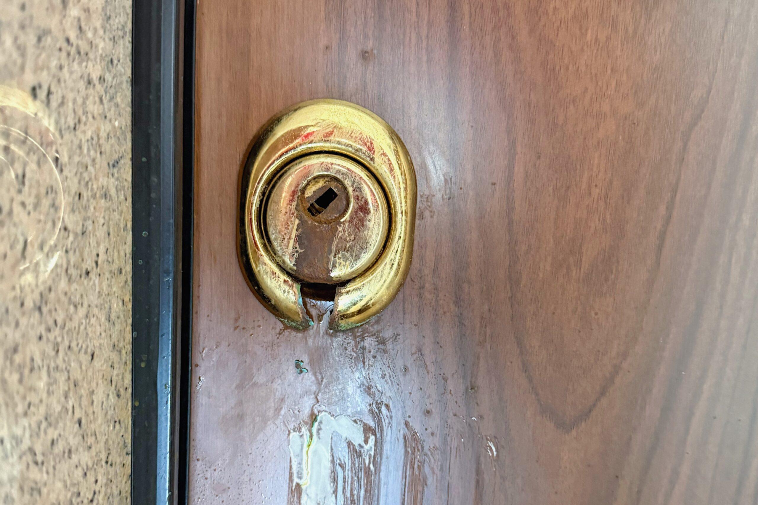 Serratura di una porta danneggiata da sostanza corrosiva dopo un tentativo di effrazione a Trieste